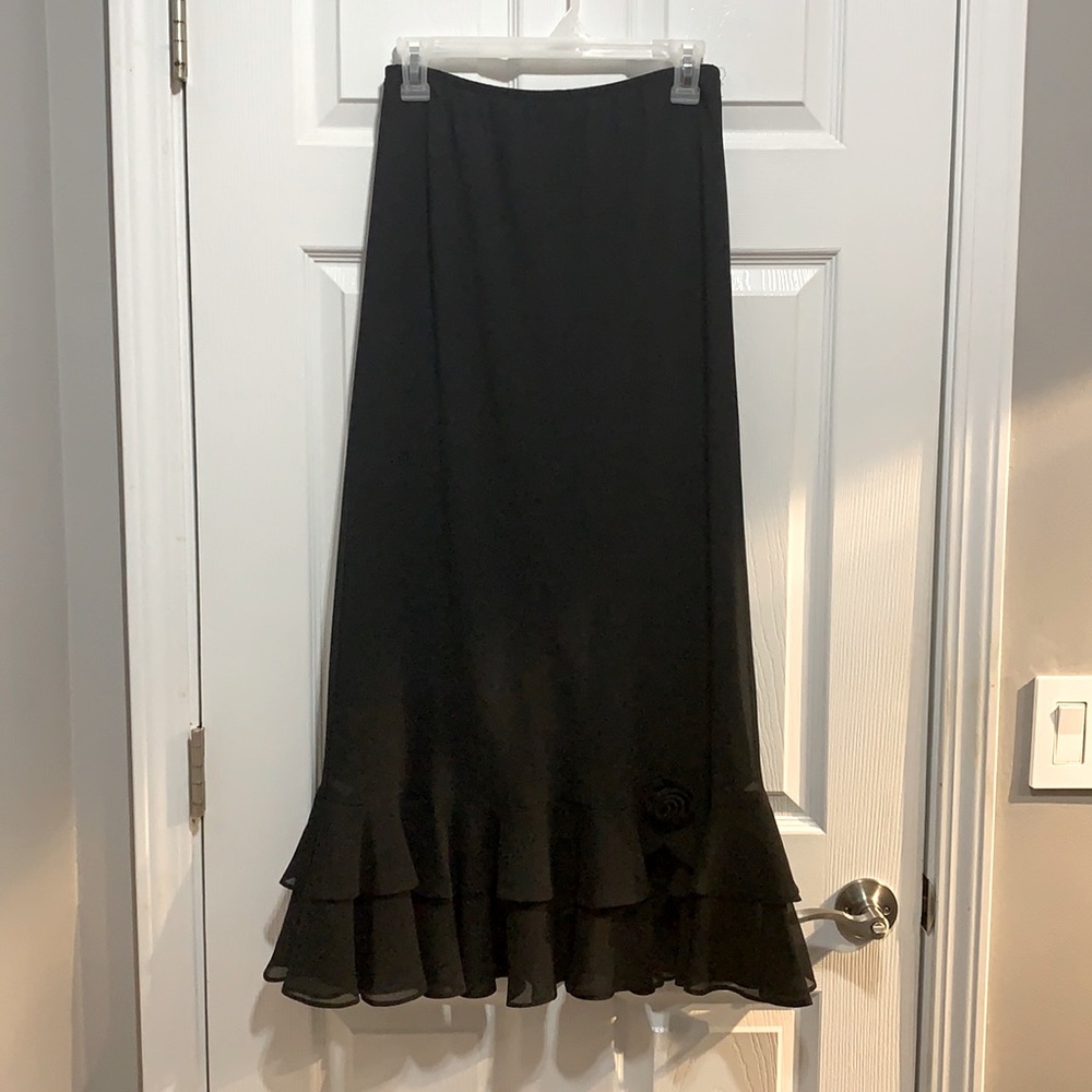 Black long skirt with a rose on it on the bottom.